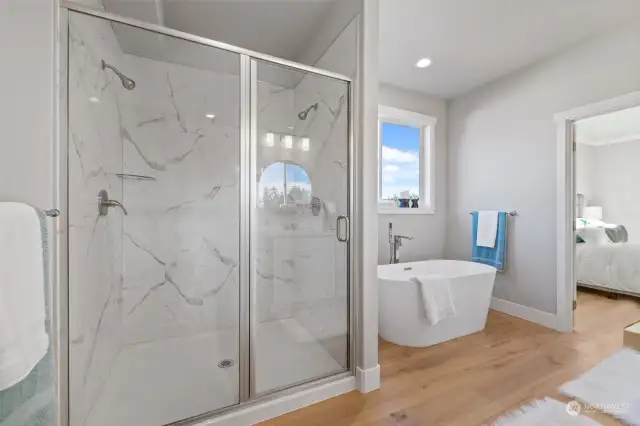 Experience everyday luxury in the primary bath, with a sleek walk-in shower, modern finishes, and a calming, neutral color palette.