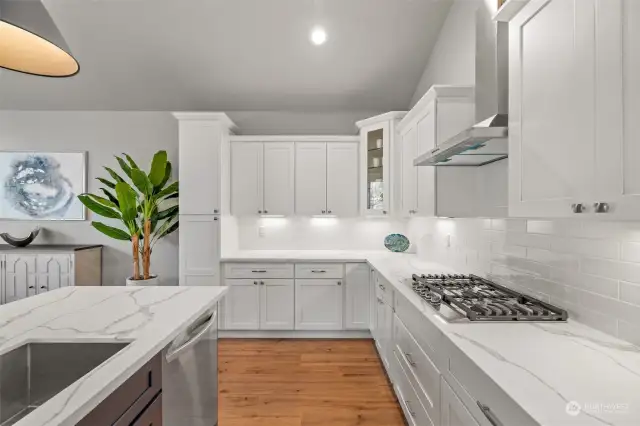 This gourmet kitchen is a chef's dream, featuring sleek white cabinets, quartz countertops, and stainless steel appliances.