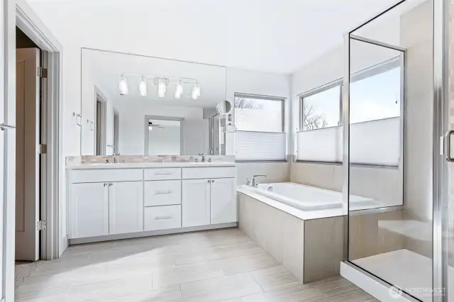 The perfect Primary bathroom - large, tiled soaking tub, dual vanity, wide & modern tile flooring soaking tub and frosted windows with top/bottom blinds for privacy