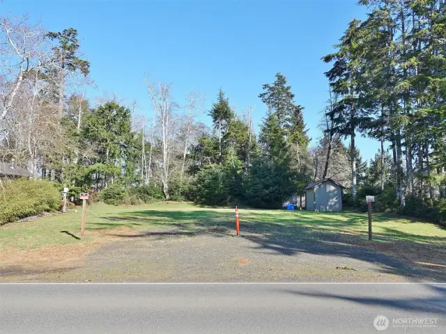 Front view of this great camping/building lot with a huge/wide driveway/culvert, water, sewer, power, shed.