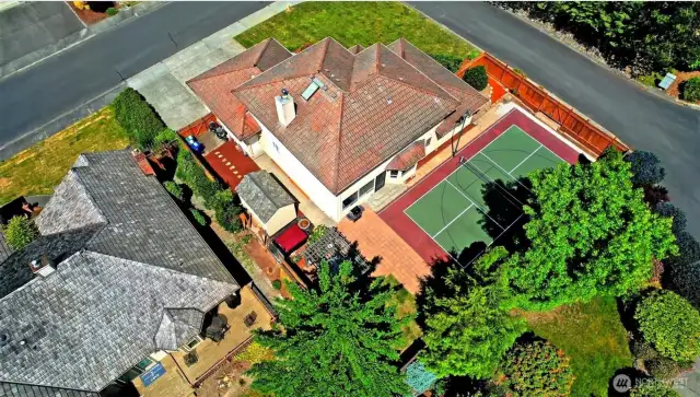 Amazing backyard with outdoor pickle ball sport court that features evening lighting.