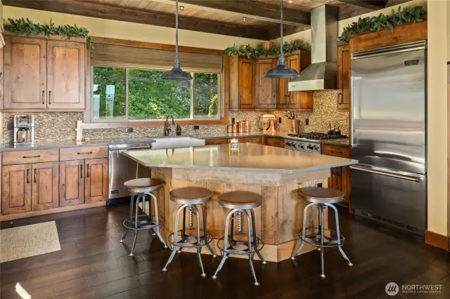 Featuring rich knotty alder distressed cabinets, sleek quartz surfaces, artisan hardware, and a classic farmhouse sink, the kitchen blends rustic charm with contemporary sophistication for both everyday comfort and memorable gatherings.