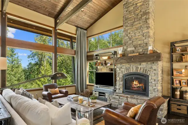 The floor-to-ceiling stone fireplace serves as the centerpiece of the great room, perfectly paired with majestic mountain views.