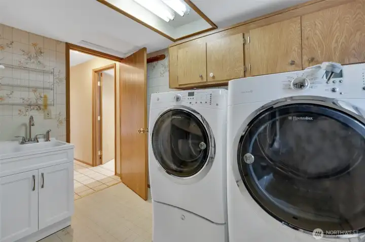 Laundry room offers a large sink with spray hose for easy clean up and storage cabinets keeping you well organized.