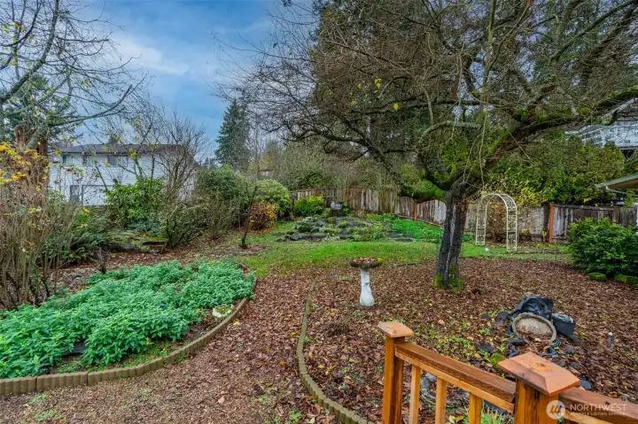 Lush landscaping blankets the yard with native plantings and garden beds.