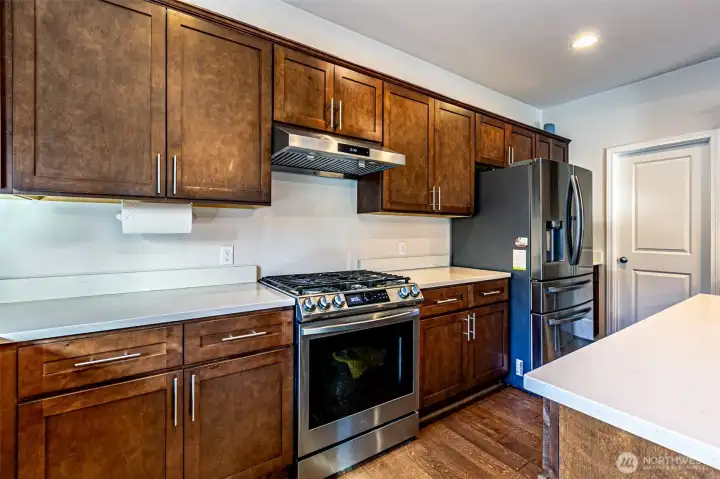 Upgraded stove, exhaust hood, fridge seen