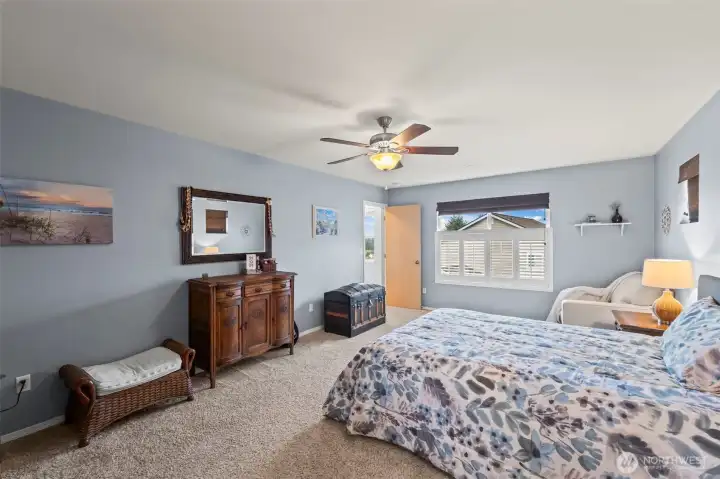 The primary suite has shutters on the large window and bamboo shades on two small windows that flank the bed. It’s spacious!