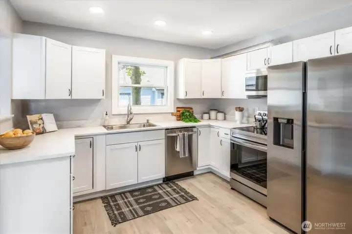 Stylish custom cabinetry with two Lazy Susans and large sink for practical use. Photos from earlier listing in 2025.