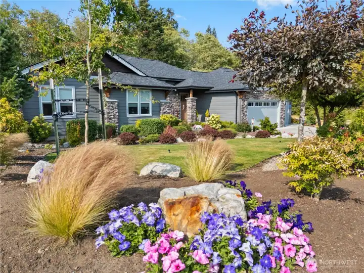 Showcasing refined Northwest craftsmanship, this beautifully landscaped home pairs stone accents and lush gardens with a welcoming design that feels both polished and peaceful.