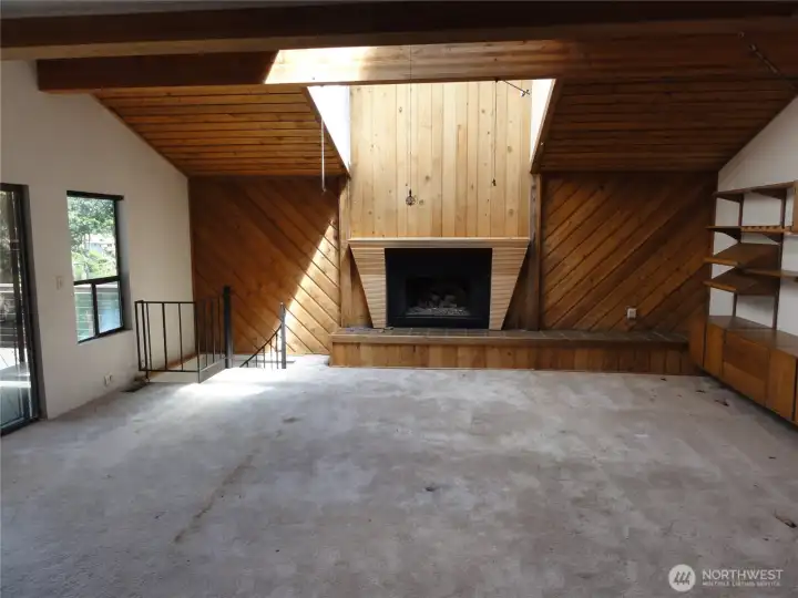 Huge family room with cathedral ceilings and fireplace. IN back corner, spiral staircase leads to the lower level.