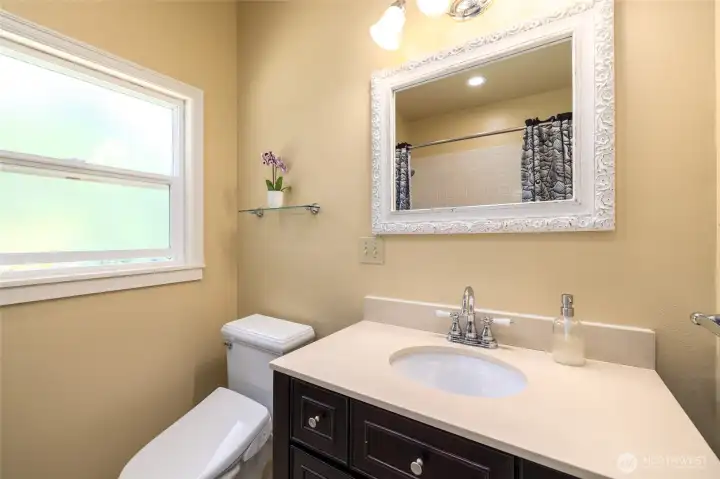 The full bathroom has tile surround around the bathtub