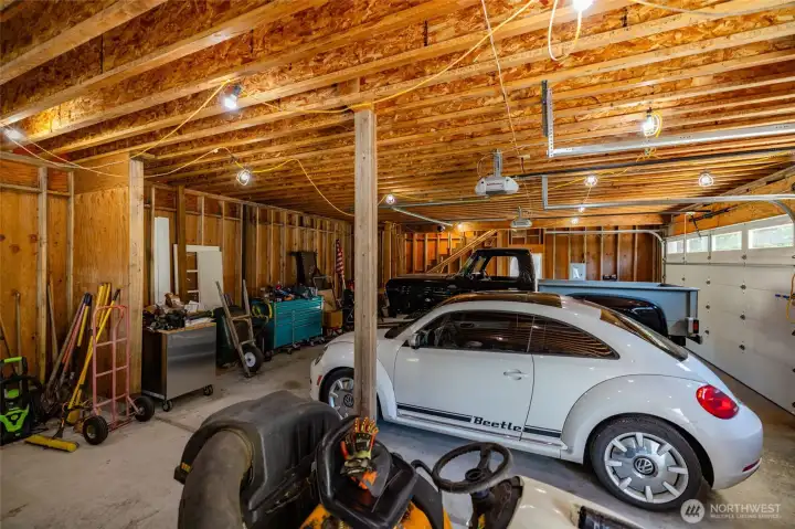 Detached shop/garage offers parking for 3 vehicles, plus a shop area.  Stairs to unfinished loft are at the far end of this photo.