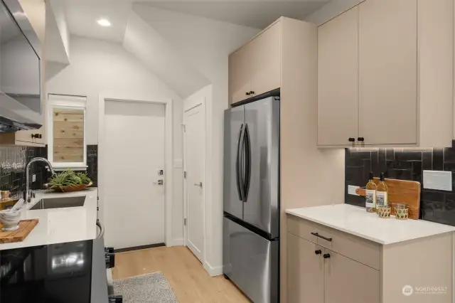 This thoughtfully designed kitchen includes sleek cabinetry and a spacious fridge, providing plenty of storage for all your culinary essentials.