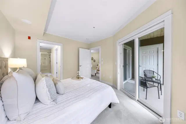 Primary bedroom view to the balcony slider living area and primary bathroom