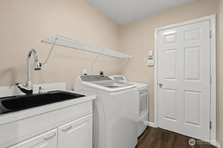Laundry room with utility sink and cabinet storage, conveniently located off the 2-car garage.
