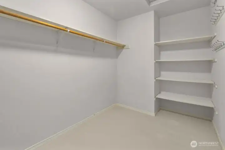 Walk-in closet with built-in shelving and plenty of storage.
