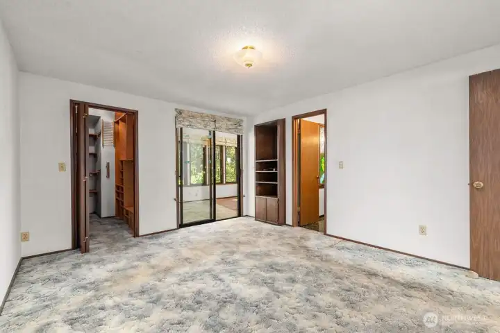 Large primary bedroom with ensuite 3/4 bath, walk in closet and access to the sunroom