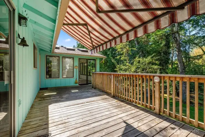 Back deck with retractable shade awning, over looks the peaceful backyard and green space.