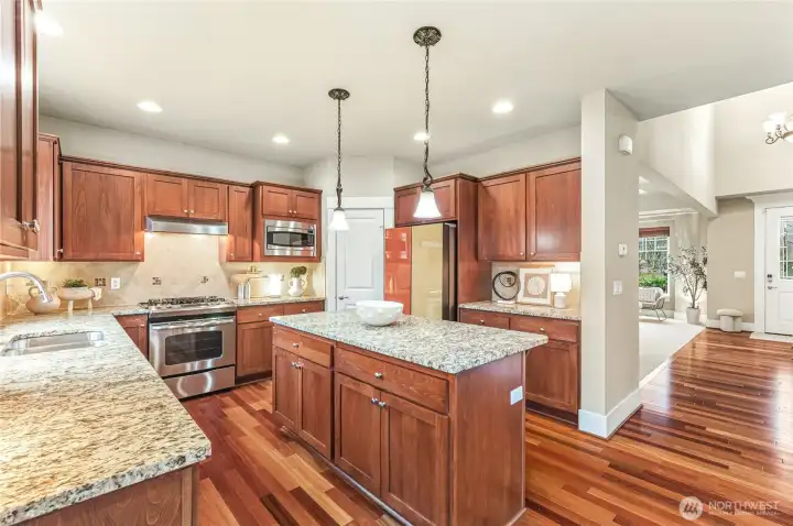 Stainless appliances, granite counters, full-height backsplash and center island to gather around