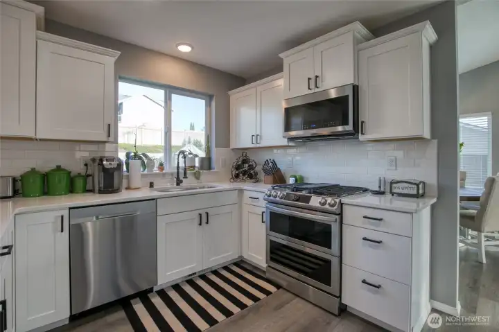 View into the back yard from the kitchen window. Updated gas range