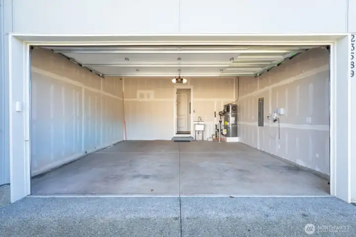 2-car garage with EV outlet/charger, storage, and utility sink.