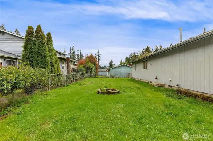 Flat backyard with firepit and space for  raised beds or room to run