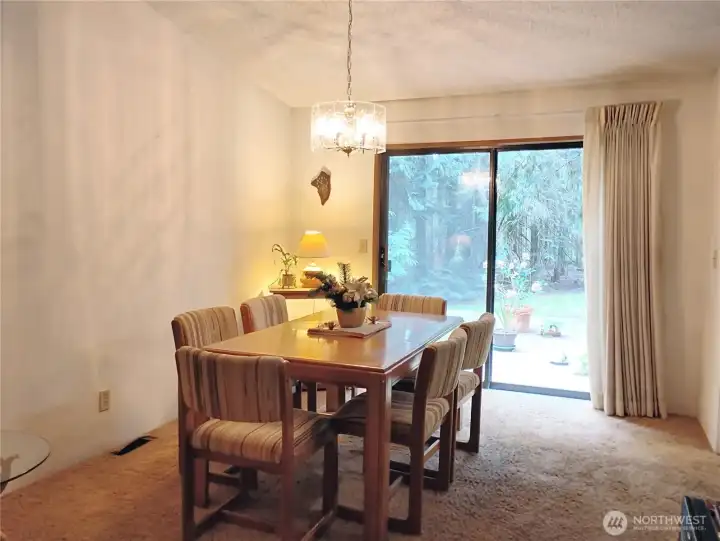 The dining room has vaulted ceiling and is open to the kitchen on the right side of this photo.