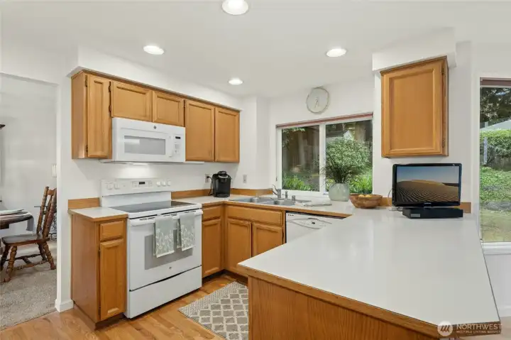 Bright, open kitchen overlooks a casual eating nook offering private backyard views.