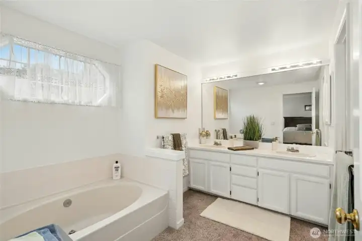 Bathroom has a dual vanity, sunken tub and separate shower.