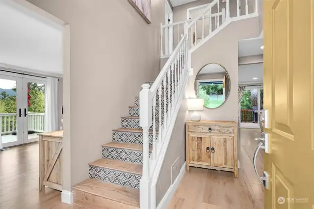 Gorgeous foyer showing off the hardwood flooring and tastefully tiled stairway!