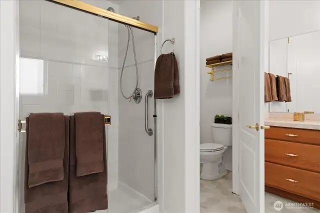 Nicely appointed primary bath with walk-in shower with built-in bench, and private water closet