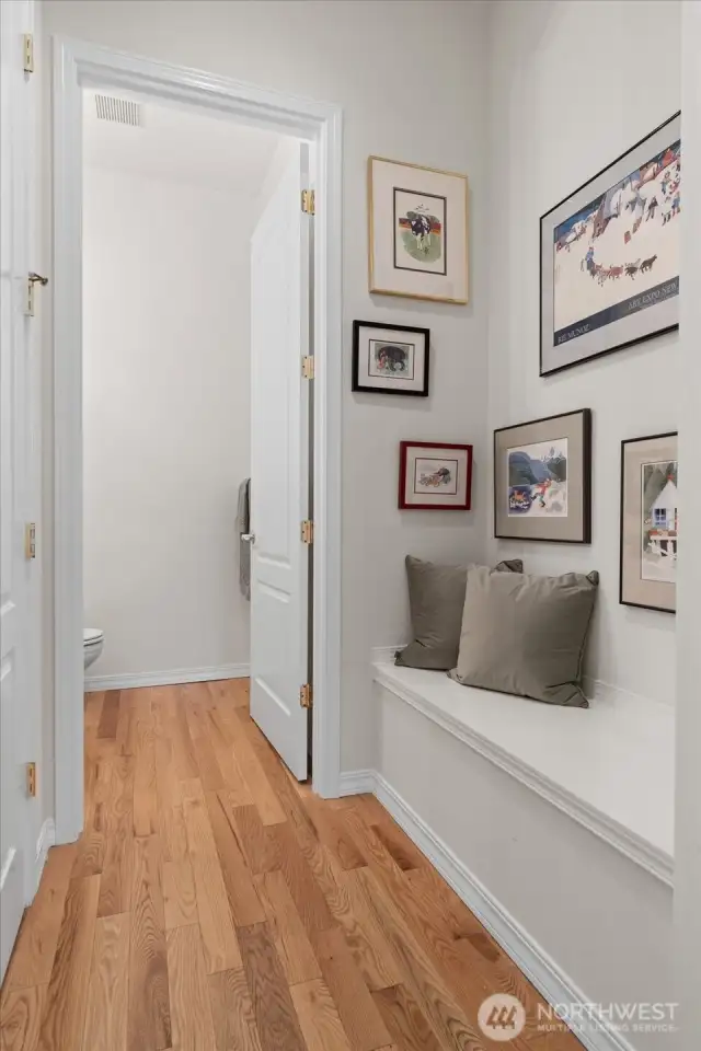 Convenient built-in bench off entrance, adjacent to powder room and coat closet, provides the perfect spot to remove shoes and coats