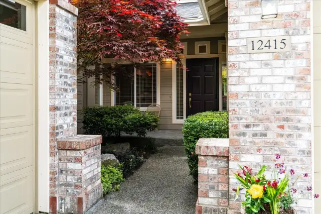 Pleasant walkway lined with mature landscaping offers a welcoming approach