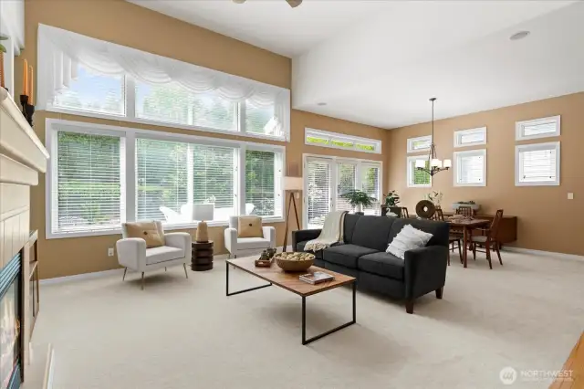 Surrounded by windows offering views of lush green landscaping, the main living areas feel light and airy