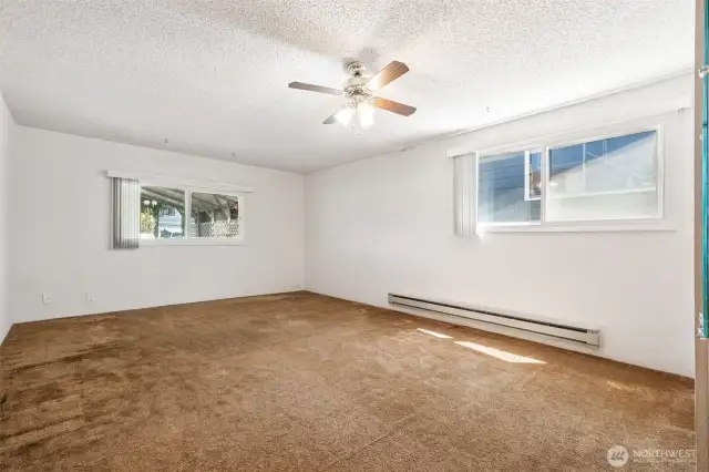 Generous sized bedroom with a wall of closets and ceiling fan. These are double-pane windows.