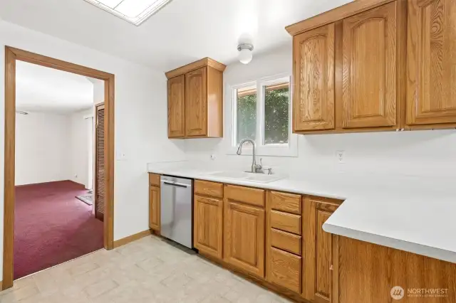 Kitchen window looks out into the backyard. To the left in the photo is the large family with ceiling fan and slider to the deck.