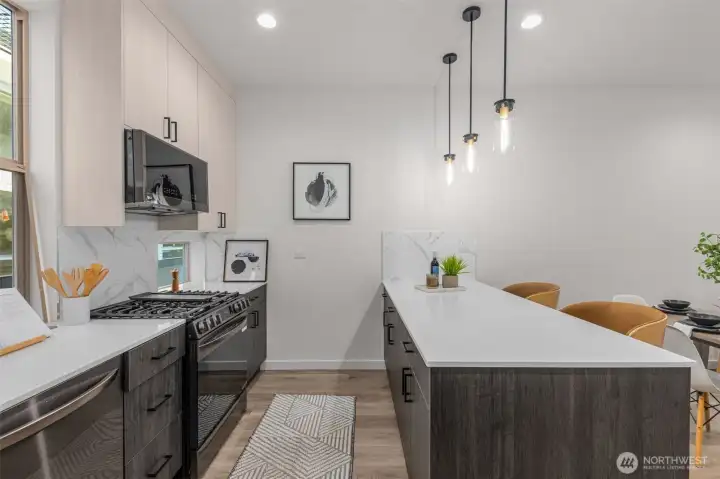 Photos of Model Home. Alternate kitchen view highlighting pendant lighting, stainless steel appliances, and thoughtful layout. Every detail reflects modern efficiency.