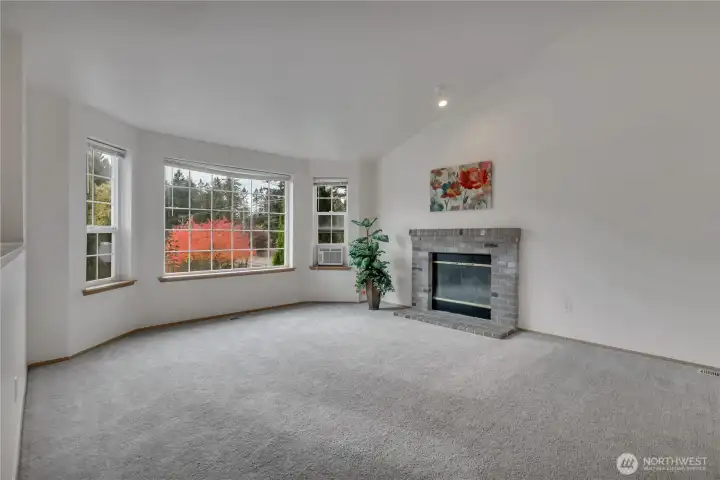 Living room with bay window.  Cozy up to the fireplace.  Perfect place for gatherings.