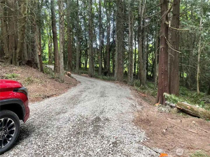 Level gravel access through tranquil and private forest.