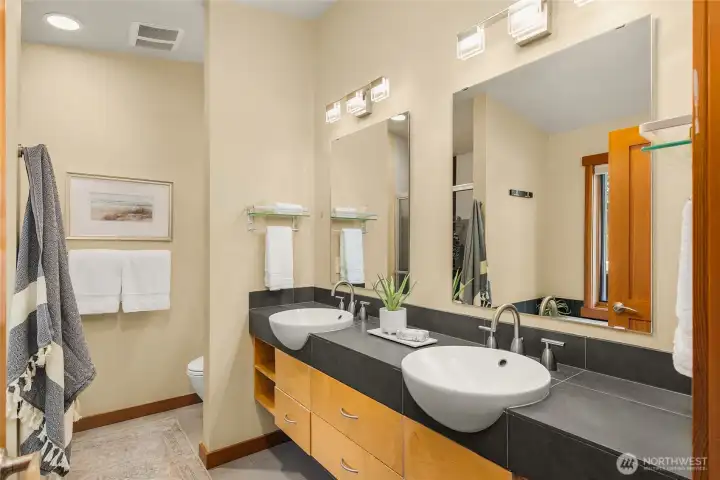 Primary bath has 2 sinks and large counters. A glass door shower is out of view.