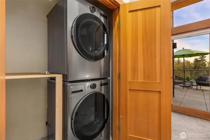 Full sized stacked washer and dryer in the upper level closet.