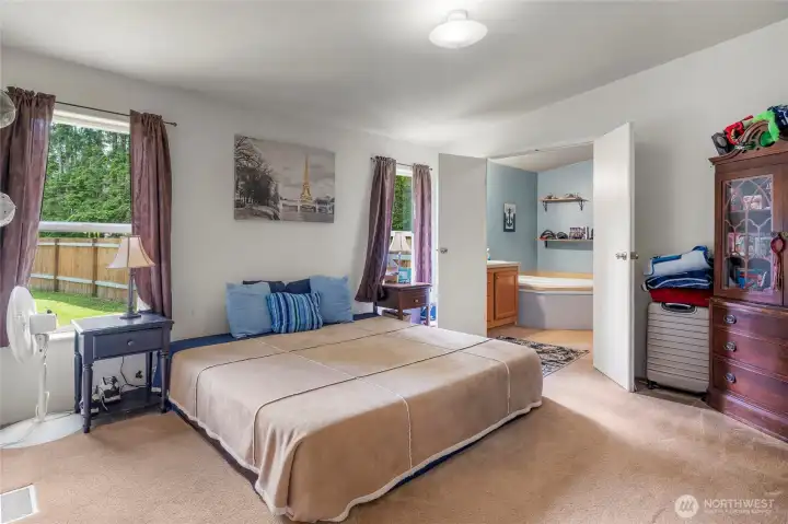 Large primary bedroom with vaulted ceilings and access to spacious en-suite bathroom.