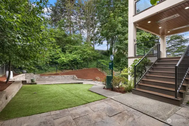 From this deck, one can access the very private backyard which combines turf and multiple patios.