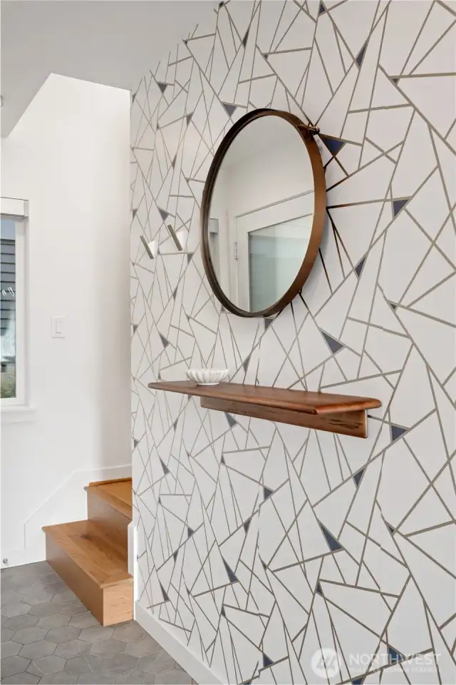 Entry with stylish hexagon tile and hardwood stairs leading to the second level.