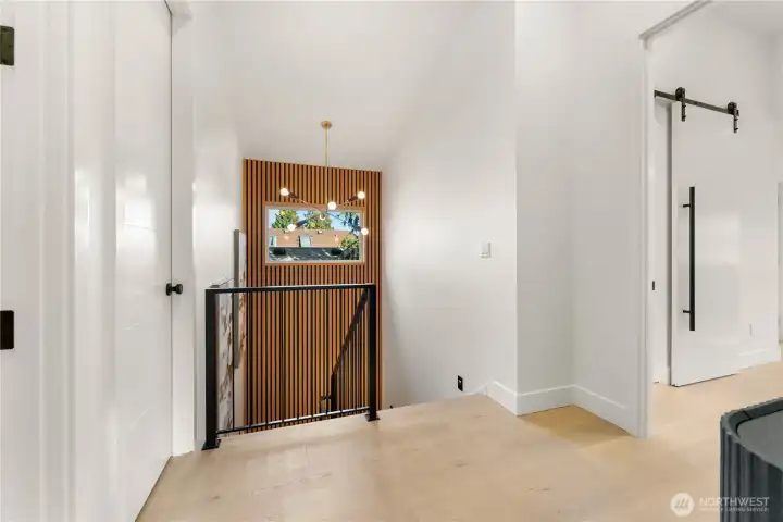 Upstairs staircase landing. Primary suite to the right. Bedrooms 2 & 3 to left.