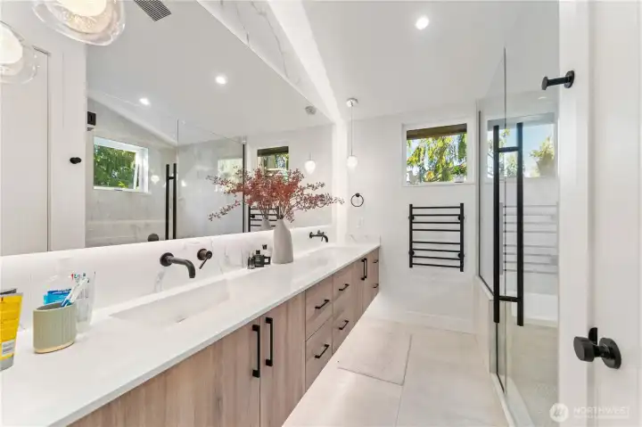 Primary bath with custom lighting, heated tile floors, double vanity, towel warmer.