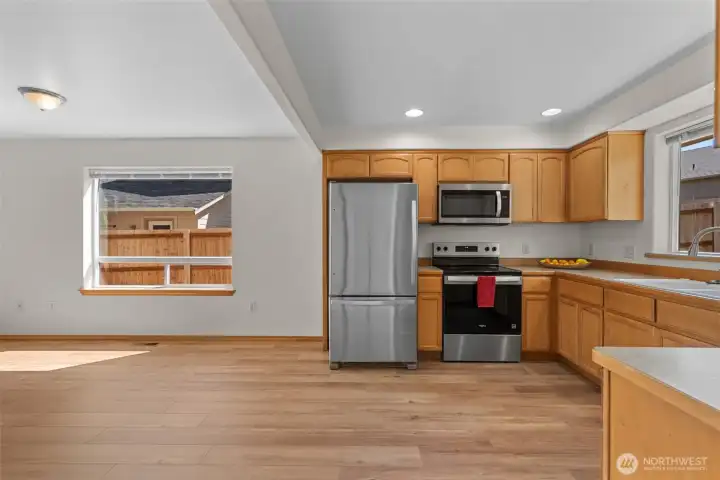 Vaulted kitchen with new appliances and just installed luxury vinyl flooring through family room