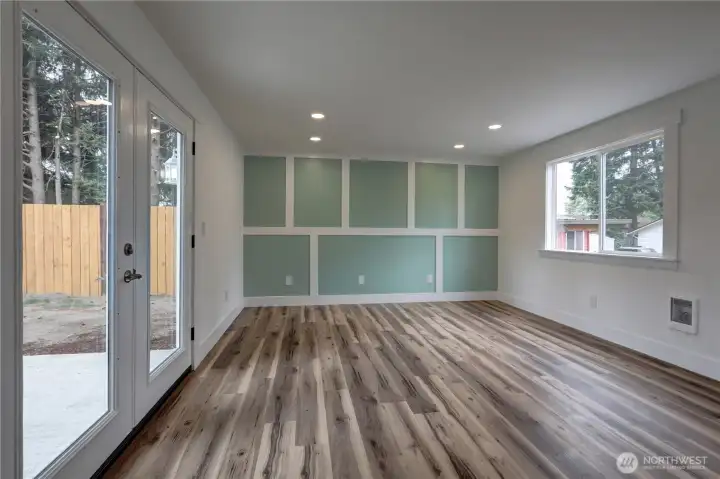 Bright and inviting living space with wide-plank flooring, recessed lighting, and stylish accent wall details.