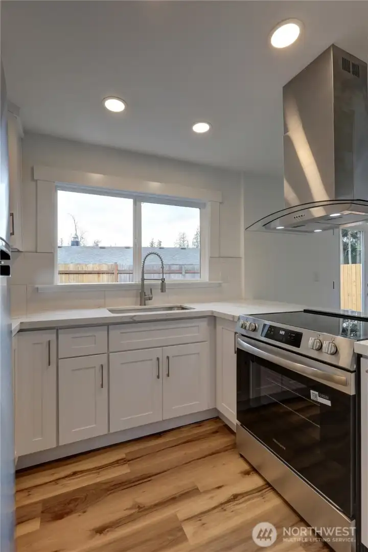 Designer kitchen featuring quartz countertops, stainless steel appliances, and custom cabinetry.