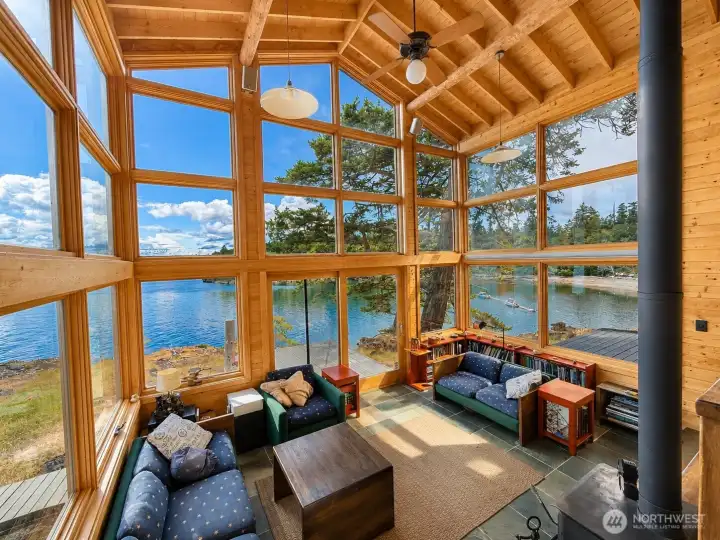 Living room with walls of windows and cathedral ceiling. Living room with walls of windows and cathedral ceiling.
